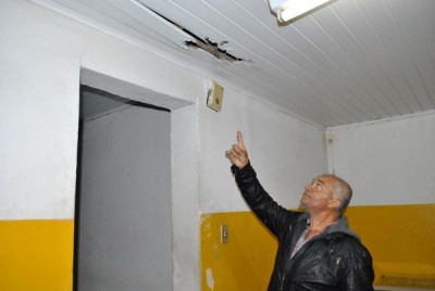 Fernandes aponta o teto danificado